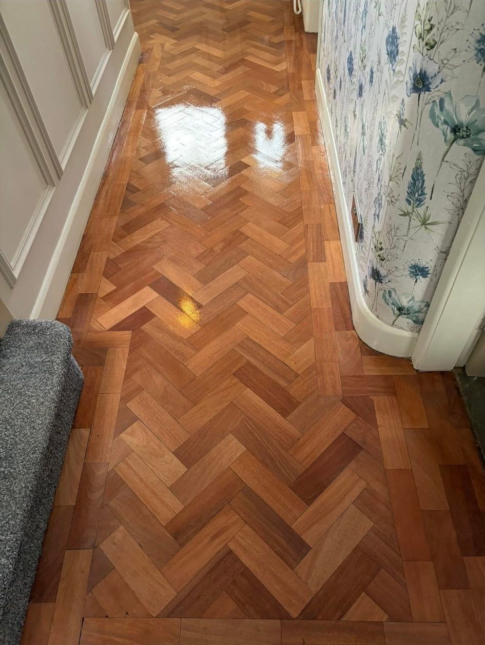Narrow herringbone hallway with floral wallpaper, after sanding and refinishing