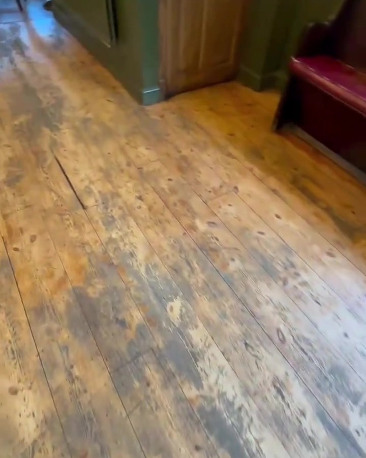 Pine floorboards in a pub style room before restoration, worn and stained